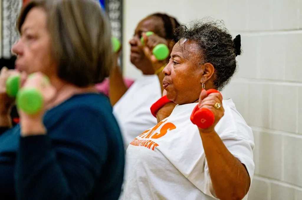 Пожилые женщины занимаются с гантелями